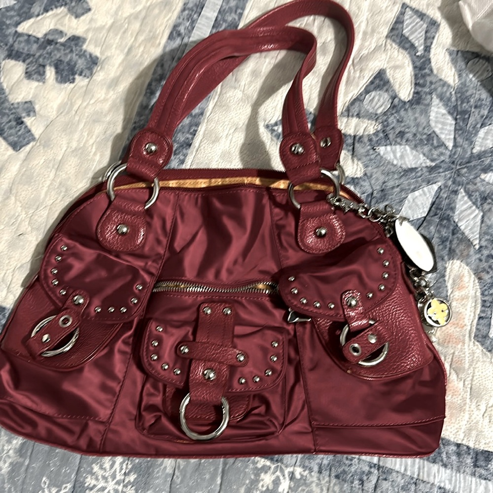 Kathy Van Zeeland, red fabric bag with leather accents and charms